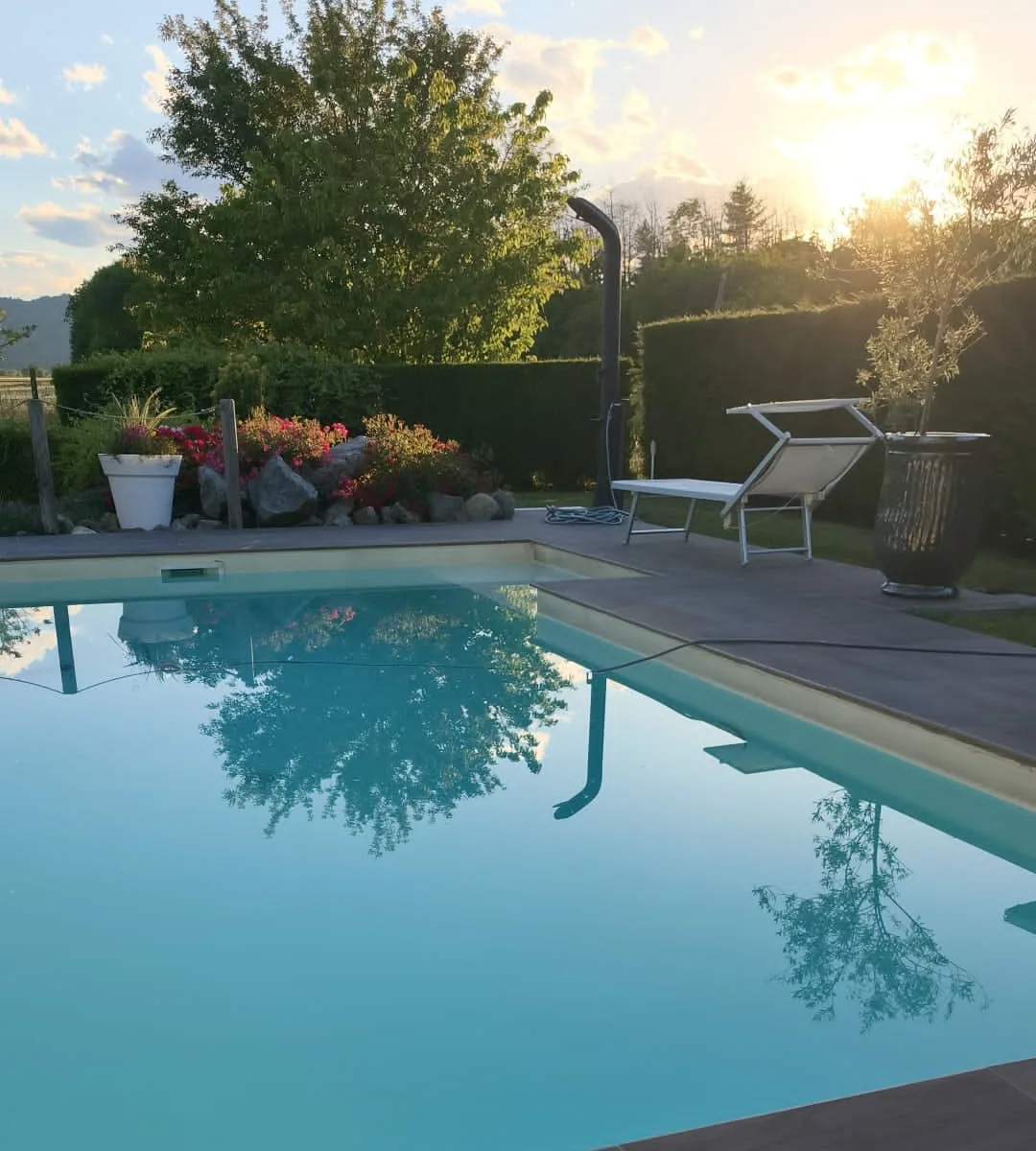Bordo e pavimento di una piscina: piastrelle effetto legno, posate sul bordo e tutt'intorno alla vasca