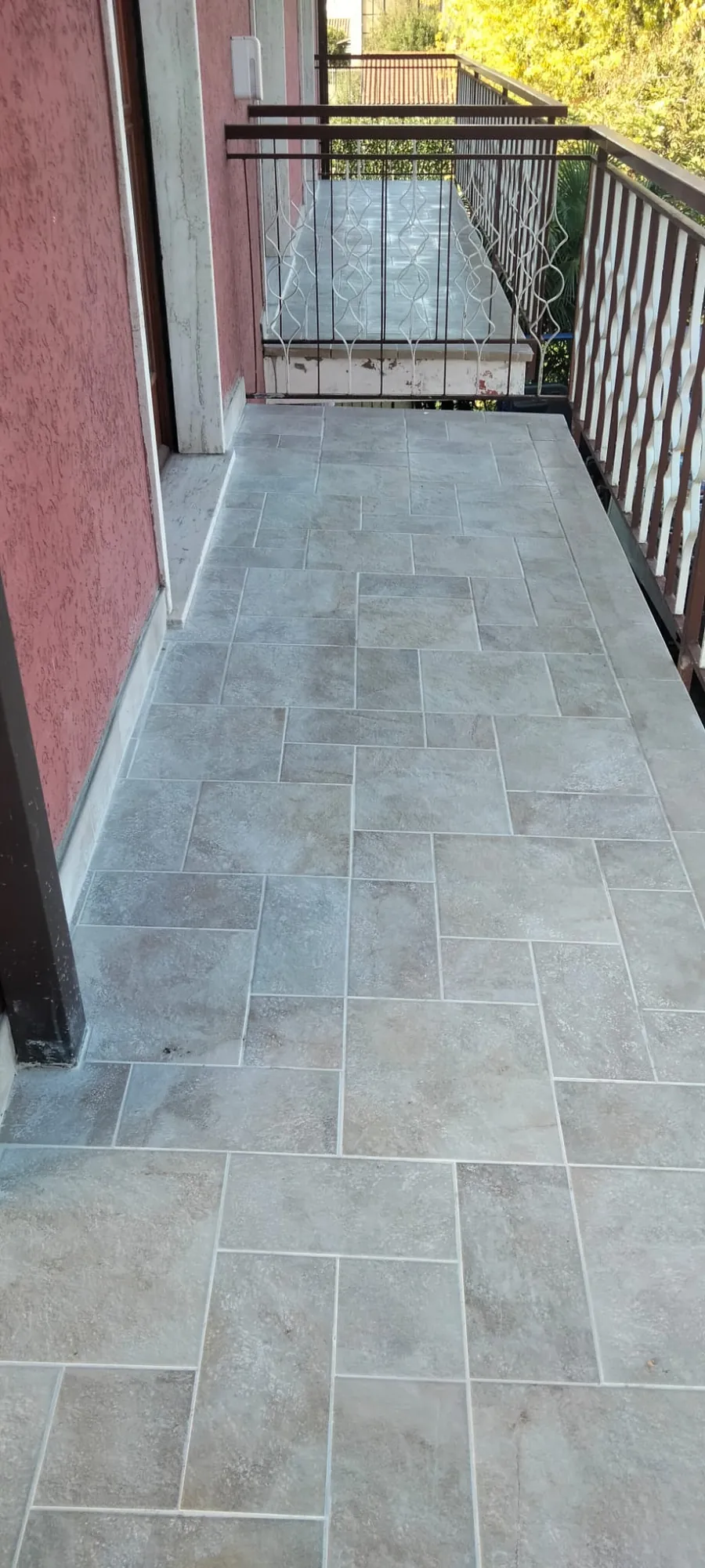 Pavimento di un balcone: piastrelle effetto pietra in più formati, da un capo all'altro del balcone