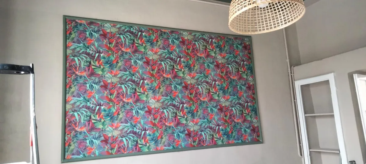 Carta da parati a fiori: foglie e fiori su una parete, dentro una cornice verde