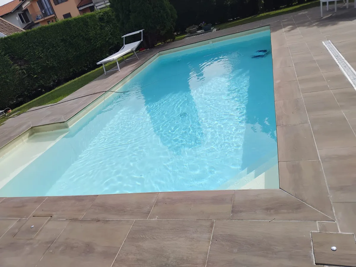 Bordo e pavimentazione di una piscina in piastrelle effetto legno