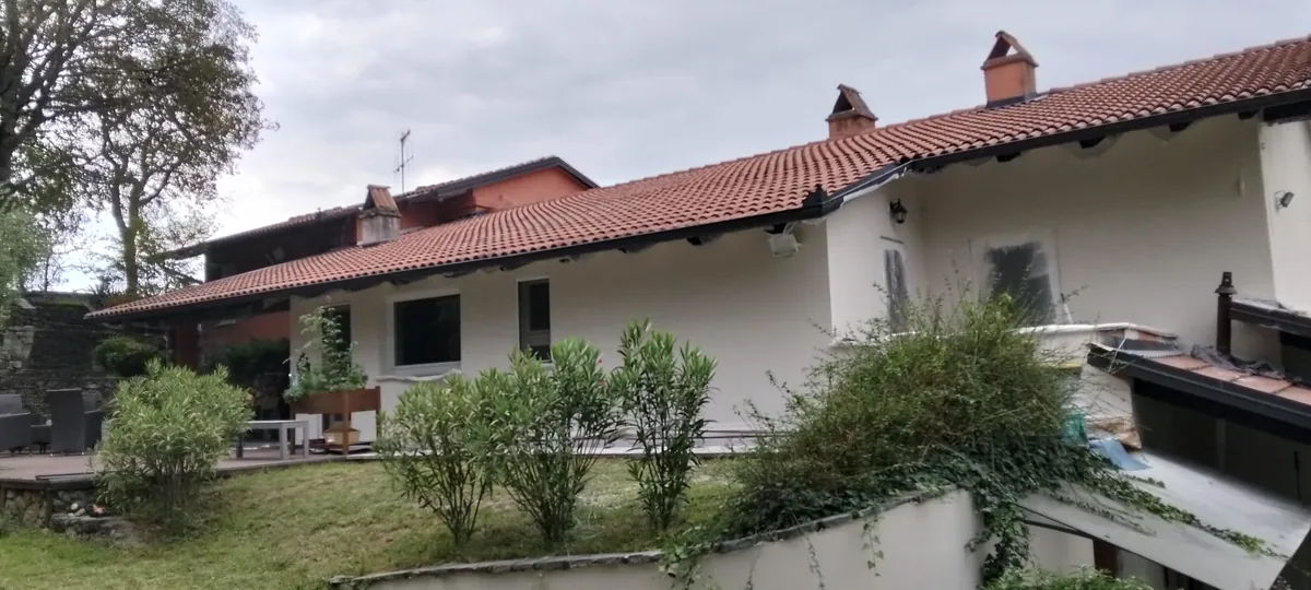 Facciata bianca di una casa col tetto in coppi